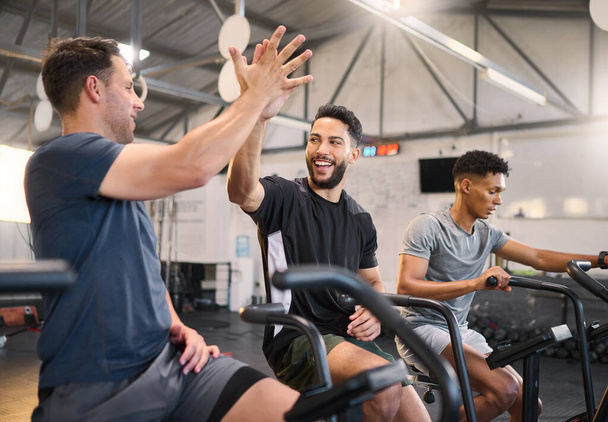 Fitness, man and high five at the gym for exercise, training or cardio workout together indoors. Happy men with smile and hands in celebration for partnership, support or sport motivation in wellness. - Photo, Image