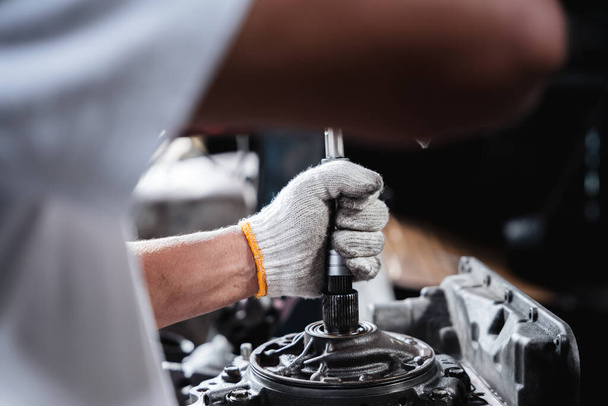 自動車修理工場では、機械工は、発生する可能性のある問題に対処するために自動車エンジンの修理と維持に取り組んでいます。. - 写真・画像