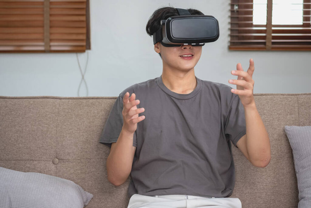 aliviar el estrés en las vacaciones Feliz asiático hombre blanco relajarse en casa jugando VR 3D juego de realidad virtual de vacaciones. - Foto, imagen