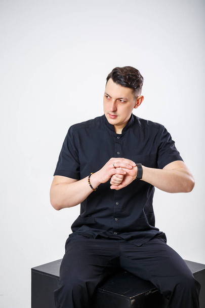 An adult man of European appearance wearing a black medical suit - Fotografie, Obrázek