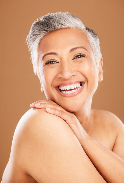 Skincare portrait, senior woman with happy smile and natural beauty cosmetics for luxury wellness. Face of indian lady, dermatology in makeup on brown studio background and healthy body positivity. - Photo, Image