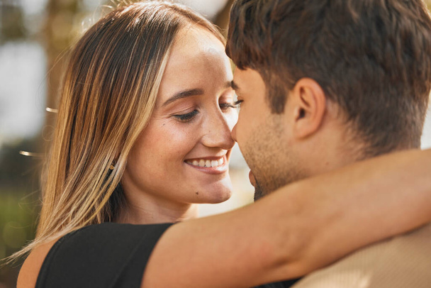 Couple, hug and love with happiness outdoor, romance and bonding with face together and nose touch. Happy, trust and romantic embrace, man and woman smile in marriage or dating relationship - Fotoğraf, Görsel