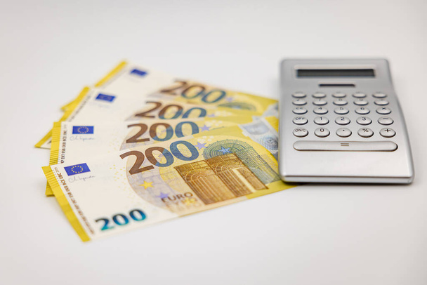 200-Euro-Scheine und Taschenrechner von der Seite mit geringer Schärfentiefe fotografiert - Foto, Bild