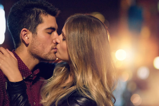That kiss you hope never ends. a young couple sharing a romantic kiss together outside at night - Foto, imagen