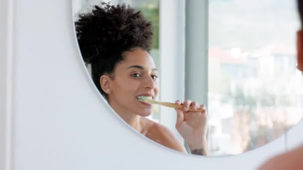 Чистка зубов, уборка и черная женщина с зеркалом в ванной утром, делая стоматологическую гигиену. Женщина со здоровьем и зубной щеткой с зубной пастой чистый рот для оздоровления дома с рутиной. - Кадры, видео