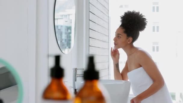 Skincare, black woman and beauty, cleaning and facial in a bathroom for hygiene, grooming and cosmetics. Face, woman and skin product for cleansing, toner and face cream by girl, mirror and shower. - Footage, Video