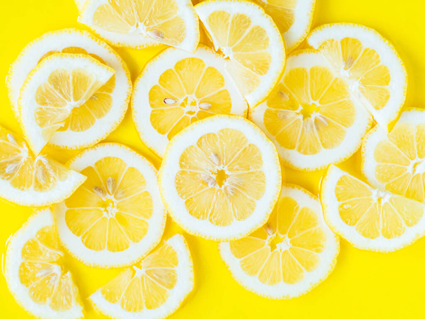Cítricos limón rebanadas en agua con ondulaciones, audaz textura amarilla fondo de verano. Verano belleza fresco telón de fondo - Foto, imagen