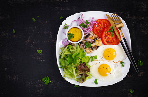 Comida cetogénica. Ovos fritos, cogumelos e tomates fatiados. Keto, pequeno-almoço pálido. Vista superior, sobrecarga, espaço de cópia - Foto, Imagem