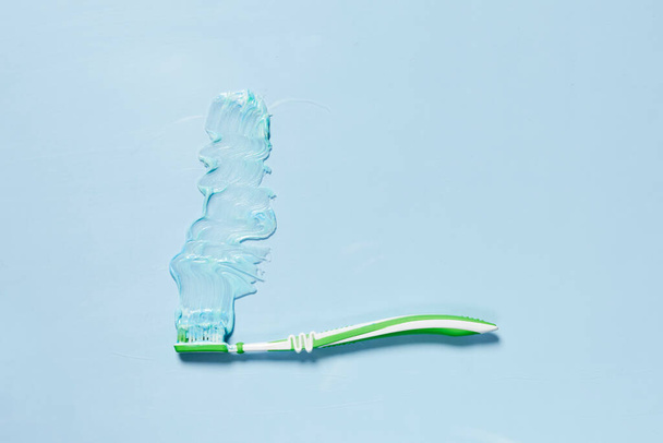 a toothbrush on a light blue background with copy space in the top right hand corner to the left side - Foto, Imagem
