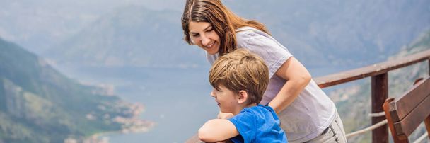 BANNER, LONG FORMAT Mother and son travellers enjoys the view of Kotor. Montenegro. Bay of Kotor, Gulf of Kotor, Boka Kotorska and walled old city. Travel to Montenegro concept. Fortifications of - Foto, Imagem