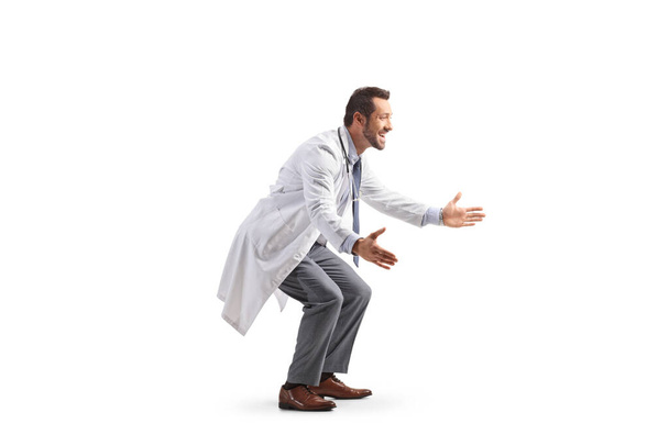 Vollständige Profilaufnahme eines männlichen Arztes, der darauf wartet, jemanden zu umarmen, der auf weißem Hintergrund isoliert ist - Foto, Bild