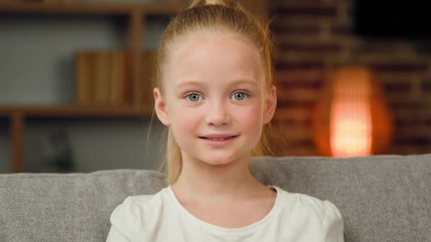 Cute girl small child caucasian baby looking at camera portrait beautiful kid face friendly emotion posing at home room close up female portrait young teenage schoolgirl toddler pupil joyful smiling - Footage, Video
