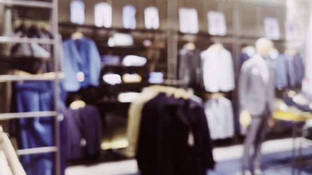 Moda, handel detaliczny i sklep, nieostry widok wnętrza sklepu odzieżowego w luksusowym centrum handlowym jako nieostre tło. Wysokiej jakości materiał 4k - Materiał filmowy, wideo