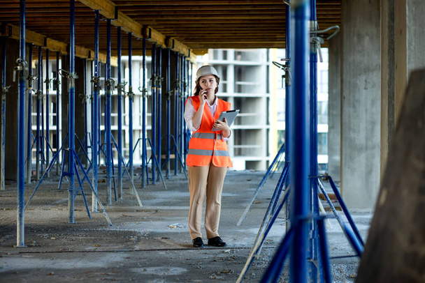 Construction concept of Engineer or Architect working at Construction Site. A woman with a tablet at a construction site. Bureau of Architecture. - Foto, imagen