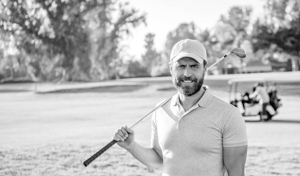 people lifestyle. smile man after game on green grass. summer activity. professional sport outdoor. male golf player on professional golf course. portrait of golfer in cap with golf club. - Photo, Image