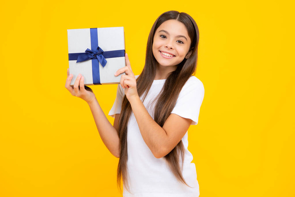 Happy teenager portrait. Teenager kid with present box. Teen girl giving birthday gift. Present, greeting and gifting concept. Smiling girl - Photo, image