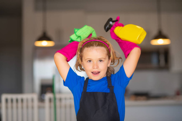 Evde temizlik yapan küçük bir çocuk. Çocuk ev işi yapıyor, eğleniyor. Mutfak arka planında ıslak düz paspasla çocuk hizmetçisinin portresi. - Fotoğraf, Görsel