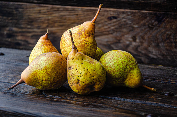 秋の庭の木のテーブルの上で香り高く食欲をそそる梨を熟す. - 写真・画像