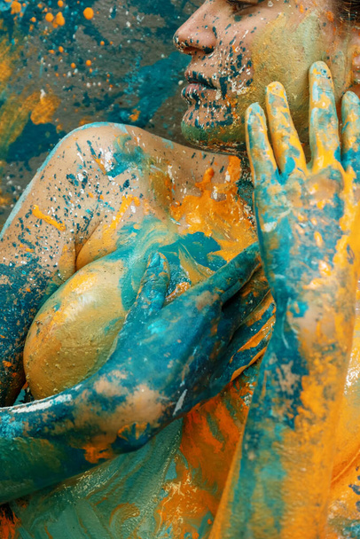 mouth, arms, hands, breast of a sexy young nude woman in turquoise green and orange color painted decorative. - Photo, Image