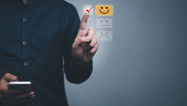 Customer service evaluation concept. male Is satisfaction on virtual touch screen. feedback with smiley face card. Service rating, satisfaction concept - Photo, Image