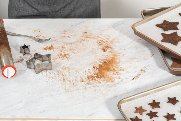Tagliare cracker di cioccolato graham a forma di stella dall'impasto con un tagliabiscotti. - Foto, immagini