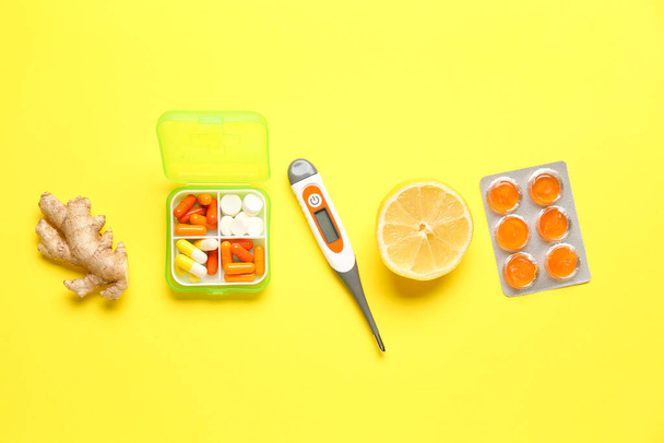 Boğaz ağrısı için ilaçlar, zencefil, limon ve sarı arka planda termometre. - Fotoğraf, Görsel