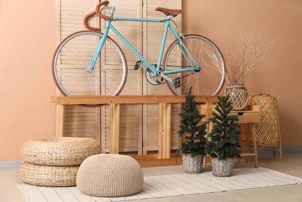 Wnętrze salonu z rowerem, półką i małymi jodłami - Zdjęcie, obraz