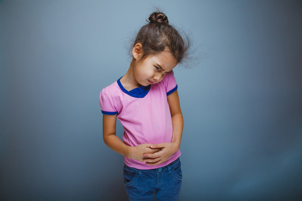 Дівчинка-підліток дитячий біль у животі на сірому фоні
 - Фото, зображення