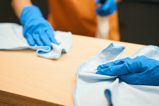 Processus de nettoyage et de désinfection atable dans un espace de coworking avec des outils spéciaux et des serviettes, un employé dans des gants de protection - Photo, image
