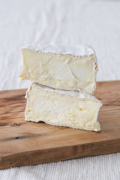 Pala kamamber brie juustoa puulaudalla. Valikoiva painopiste - Valokuva, kuva