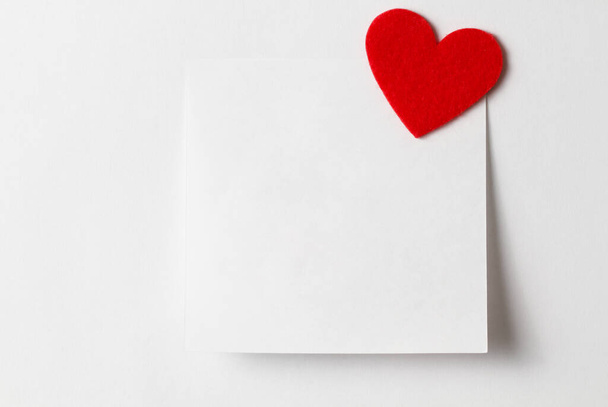 Close-up of a short white note paper with a red heart. Valentines Day background. Copy for writing text. Concept of recognition of love, romantic relationships, Happy Valentine's day - Foto, immagini