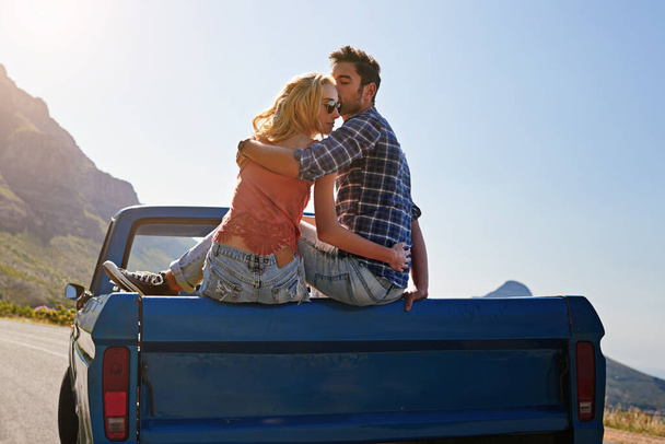 そこには開かれた道以上のものはない。若いカップルがピックアップトラックの後ろでリラックスしながら - 写真・画像