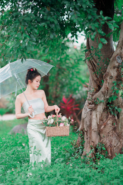Das Mädchen in traditioneller chinesischer Kleidung steht im Garten - Foto, Bild