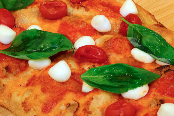 pizza or Italian focaccia cooked in a wood oven with tomatoes and buffalo cheese and basil - Photo, Image