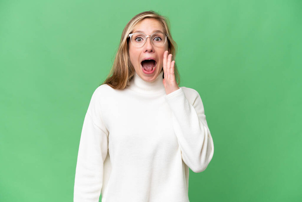 Young blonde woman over isolated background with surprise and shocked facial expression - Foto, afbeelding