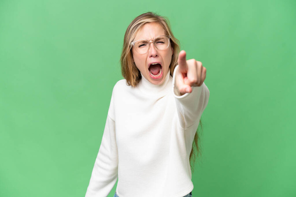Young blonde woman over isolated background frustrated and pointing to the front - Fotó, kép