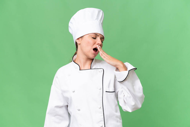 молодая женщина шеф-повар на изолированном зеленом фоне  - Фото, изображение