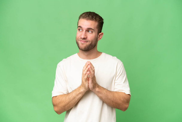 Young handsome caucasian man isolated on green chroma background scheming something - Photo, Image