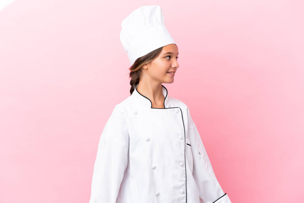 Poco caucásico chef chica aislado en rosa fondo buscando lado - Foto, Imagen