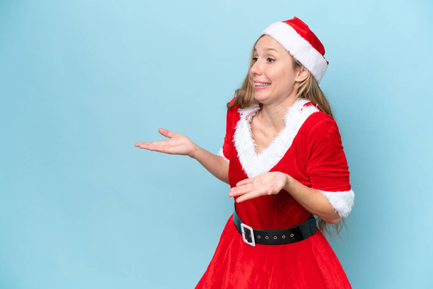 Young blonde woman dressed as mama claus isolated on blue background with surprise facial expression - Φωτογραφία, εικόνα