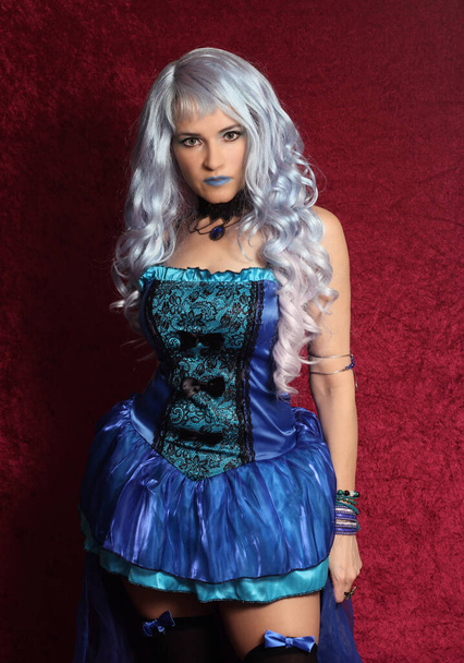 Woman With Blue Hair and Blue Corset Dress on Red Velvet - Photo, Image