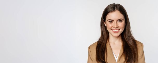 Real professional. Smiling businesswoman looking confident, determined face expression, standing in suit over white background. - Foto, afbeelding