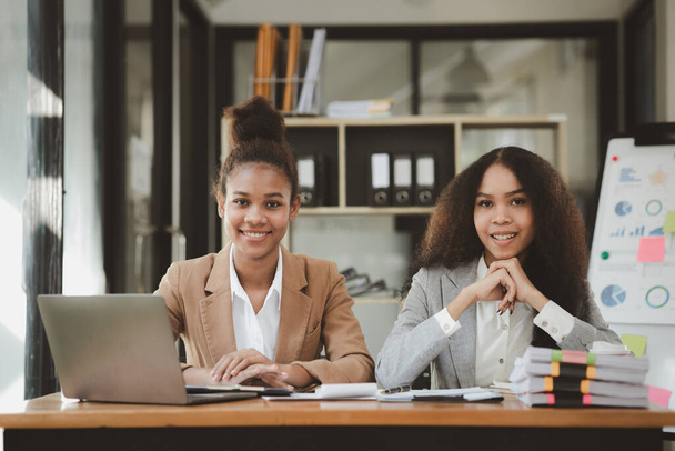 Two American women are working together in the office of a startup company. They are having a brainstorming and planning meeting in a joint department, women leading the way. Concept of women's work. - Foto, Imagem