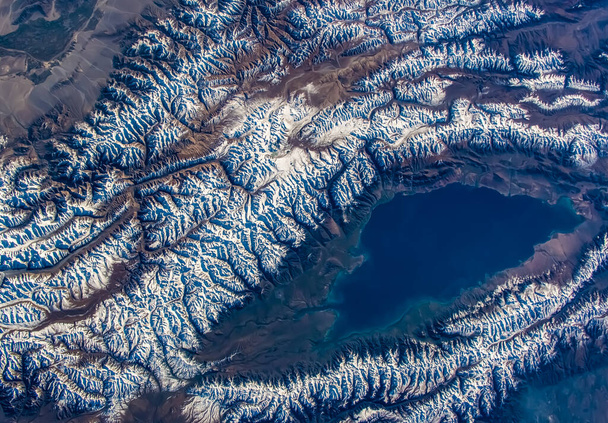 Aerial view of The Issyk-Kul Lake, Kyrgyzstan. Snow covered Tian Shan mountains. Elements of this image furnished by NASA. - Fotografie, Obrázek