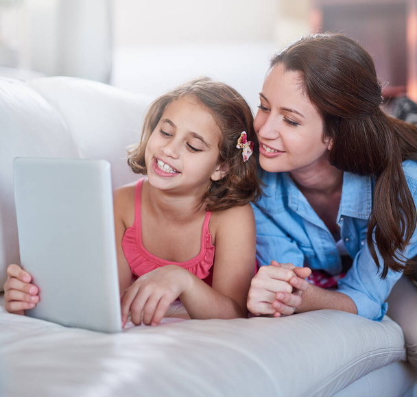Storytime goes digital. a mother and her daughter using wireless technology at home - Foto, Imagem