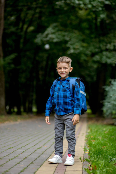 Portrait of a first grader with a backpack. The boy goes to school. - Foto, immagini