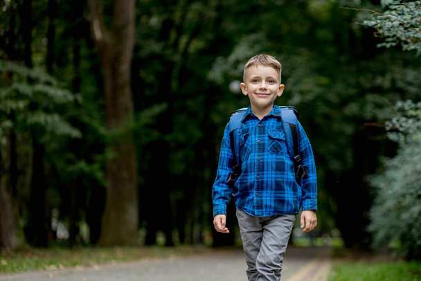 Portrait of a first grader with a backpack. The boy goes to school. - Foto, imagen