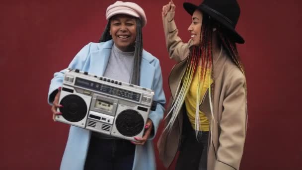Glückliche afrikanische Mutter mit ihrer Tochter, die Spaß beim Tanzen und Musikhören mit Vintage-Boombox-Stereoanlage hat - Filmmaterial, Video