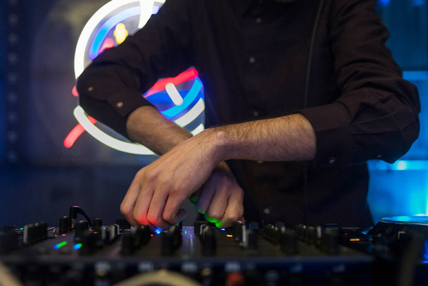 Close up view of a djs hands playing the mixer while performing. High quality photo - Photo, Image