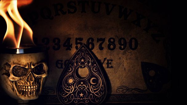 Ouija-Hexenbrett und Totenkopf in Flammen Foto - Foto, Bild